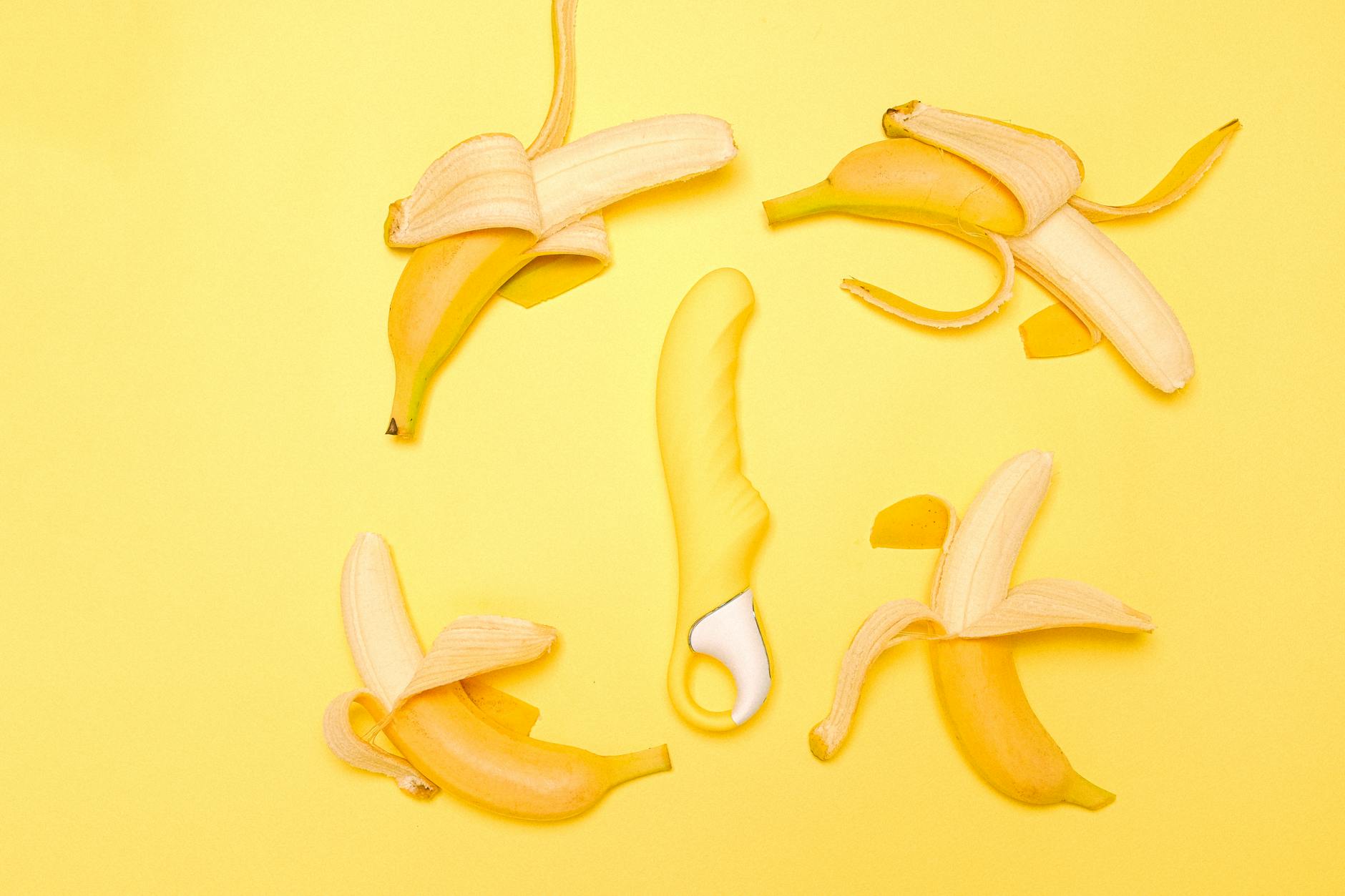 Colorful clitoral vibrators and adult toys displayed against a bright yellow background