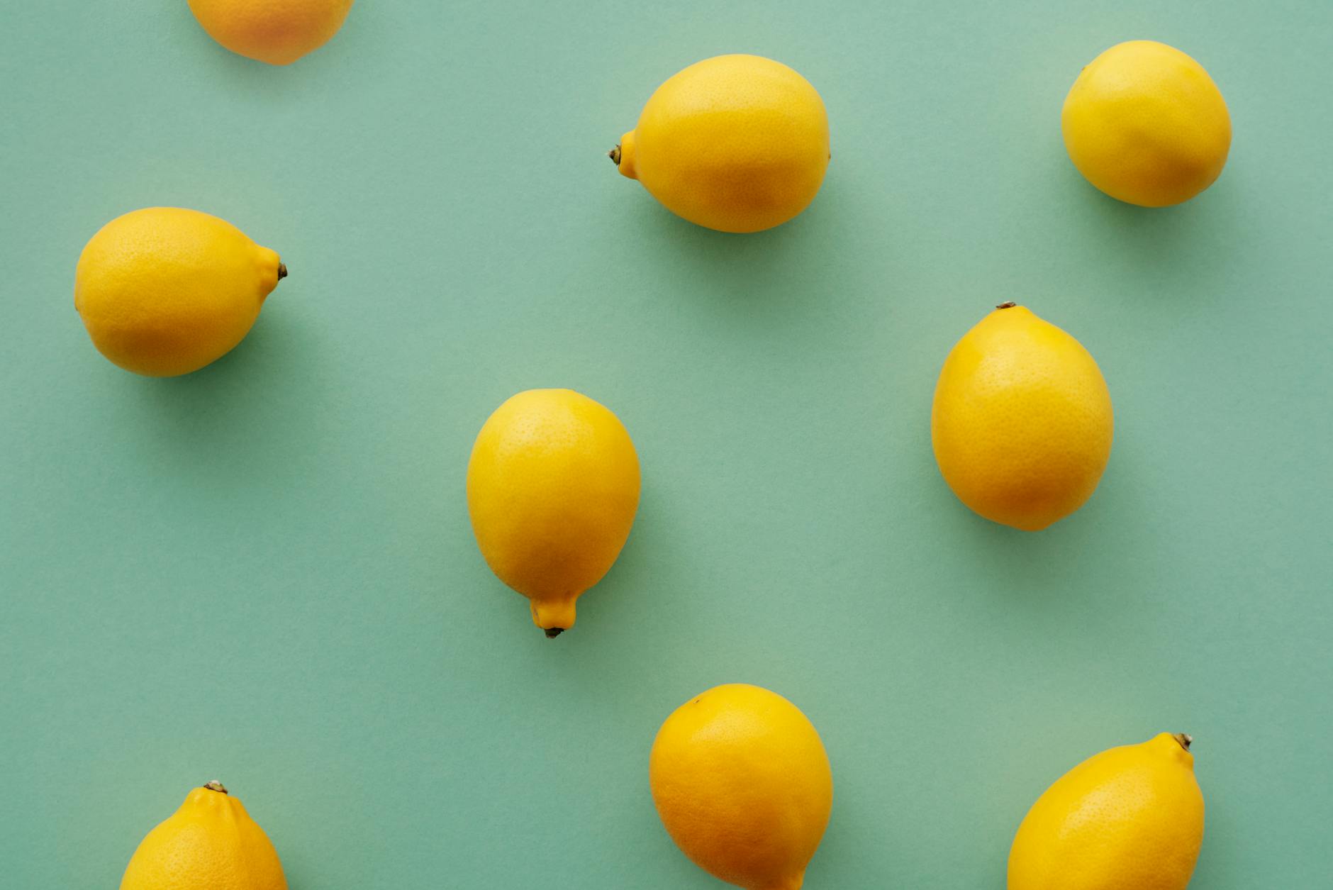 Bright yellow lemons arranged on a pastel green background, symbolizing vitality and sensation at every age.