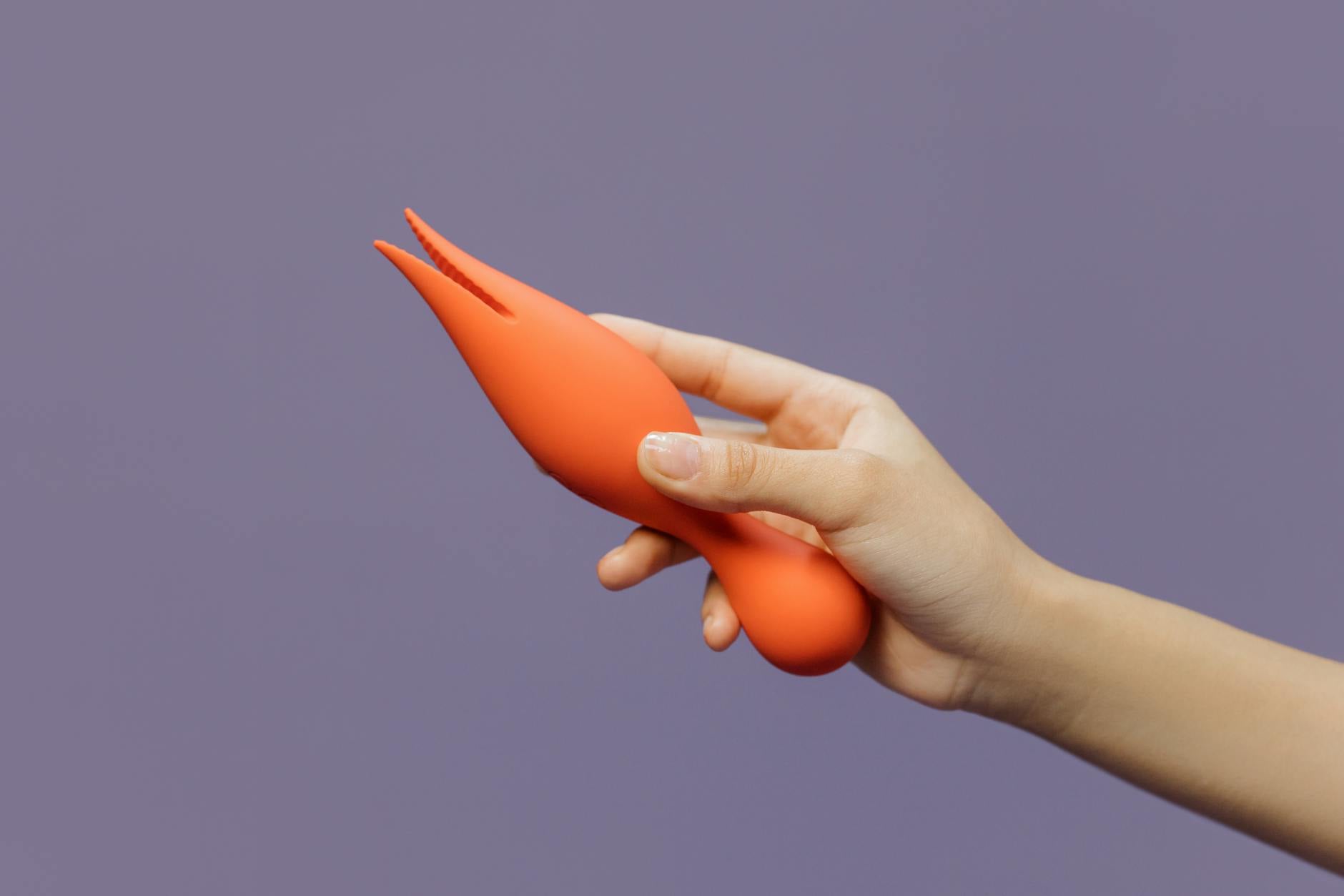 Hand holding a lemon vibrator against a minimalist backdrop, representing the delicate process of rebuilding sensation