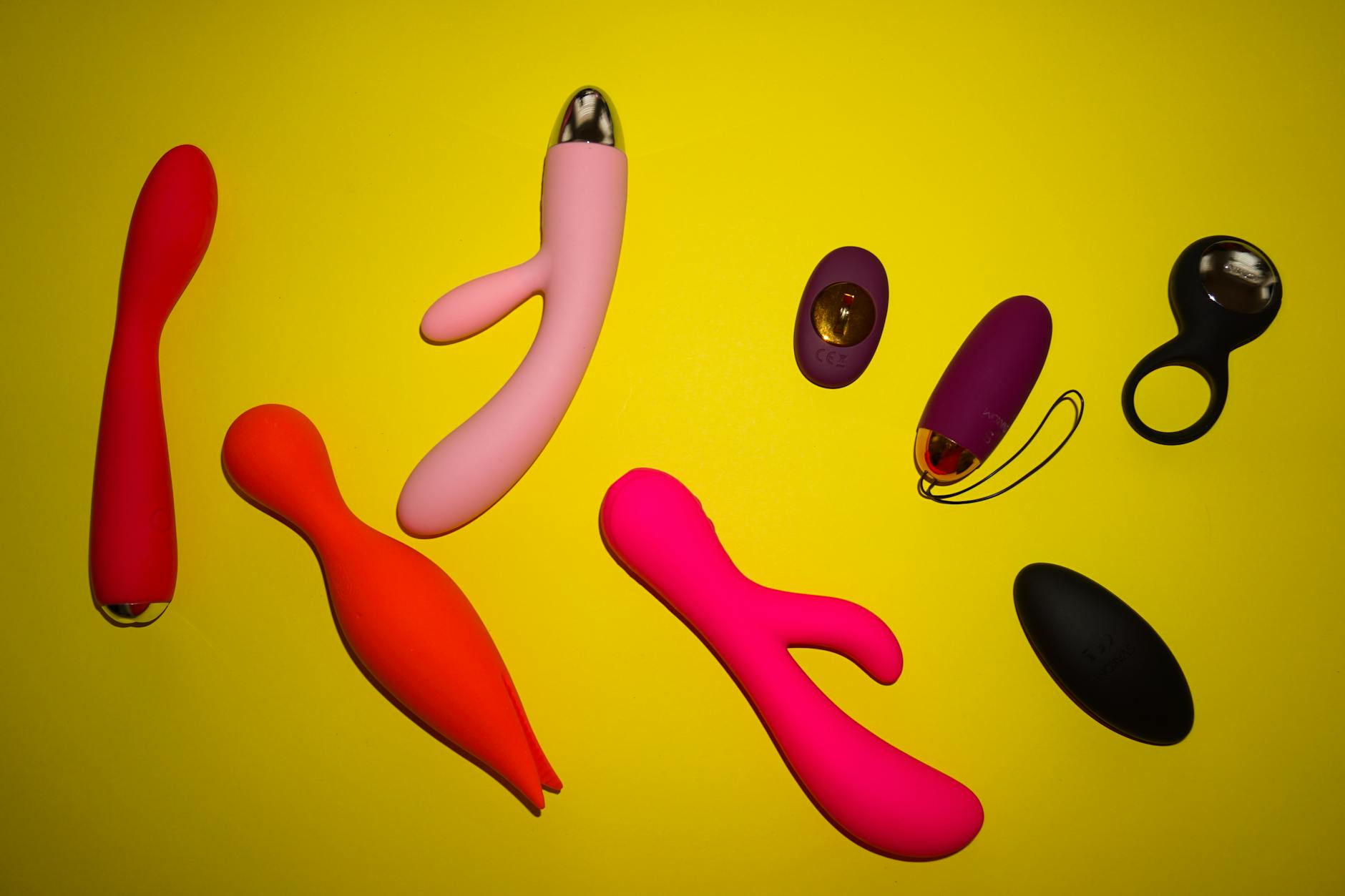 A couple's hands reaching toward a basket of colorful vibrators, representing shared pleasure and desire